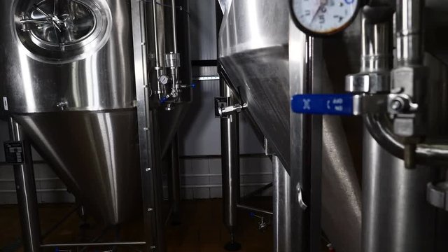 Production of beer steel reservoirs and pipes in a brewery. Beer manufacture line equipment for staged production bottling of finished food products metal piper. Modern brewery. 4k