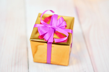 Gold gift box on wooden table