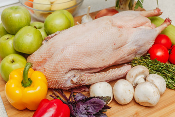 Raw stuffed goose with apples, mushrooms, herbs and vegetables