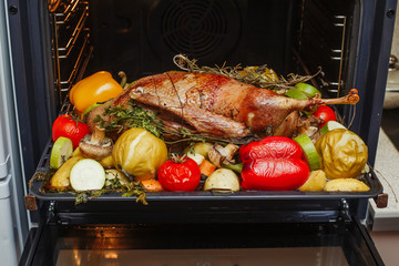 Whole roasted stuffed goose with apples, herbs and vegetables