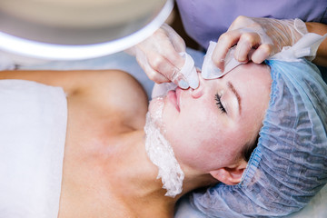 Young pretty woman enjoying a facial mask procedure