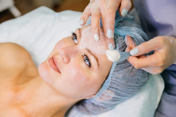 Young pretty woman enjoying a facial mask procedure
