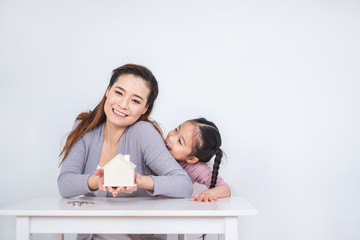 Happy Asian family inserting coins to box over white background for saving money concept