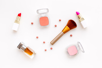 Set of pink cosmetics. Lipstick, bulk, eyeshadow, perfume near brushes on white background top view