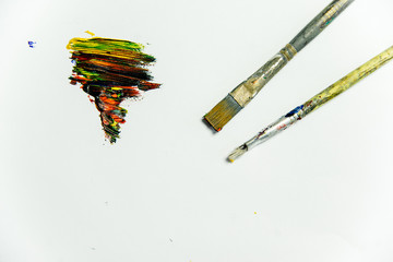 several paintbrushes with paint on a table