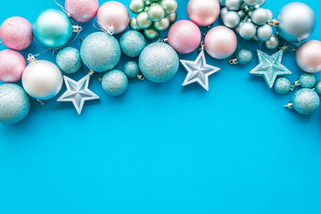 Toys for New Year tree 2019 background. Blue and pink balls and stars on blue background top view copy space border