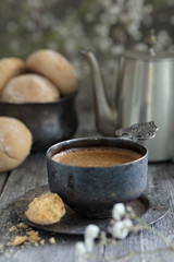 Cup of coffee, pot and cookie on wooden rustic background as a still life vertical composition