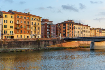 Fototapeta na wymiar View on embankment of Arno river and Solferino bridge at sunset. Pisa, Italy