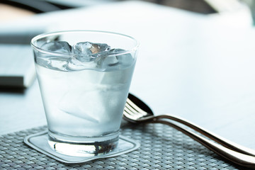 cold water and ice cube in a glass on the table in restaurant