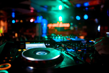 Fototapeta na wymiar DJ mixer on the table background the night club and dancing people