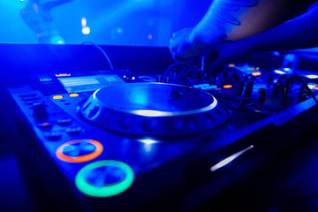 Fototapeta na wymiar Dj playing the track in the nightclub at party closeup
