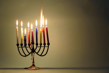 Hanukkah menorah with burning colorful candles. Retro old style photo.Copy space for text.