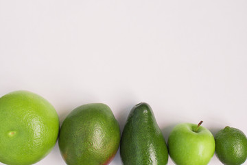 Creative background of green various summer tropical fruits. Food concept for fitness dinner,plant based diet,frutarian,healthy eating