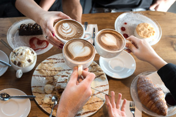 Friends with desserts and coffee, close up.Happy couple sitting around the table. Hands holding cups, happy festive moment, luxury celebration concept. - Powered by Adobe