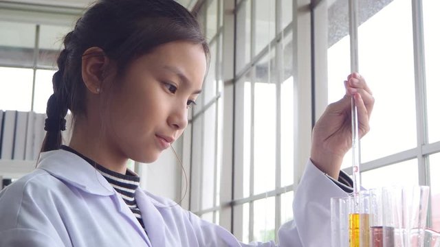 HTML5 Video is required for viewing the video
	Yong asian school girl wearing white coat and drop chemical liquid into glass tube in chemistry class at school.
