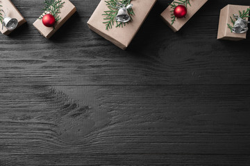 Christmas card with gifts on a dark wooden rustic background, place for text. Xmas and happy new year greeting card. Top view, flat lay.