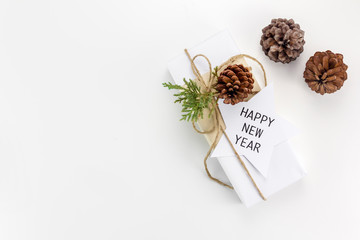 Minimal Christmas and New year flat lay gift box with pine tree and pine cone on white background