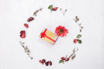 Red gift box in Christmas round frame made of natural winter things