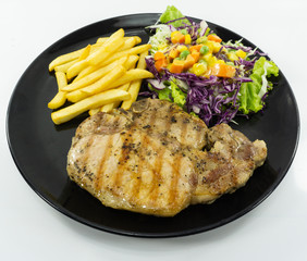 Steak Kurobuta pork chop black pepper sauce in plate on white background. props decoration French fries, green salad, Top view..