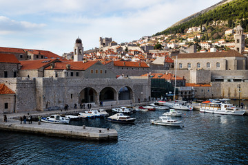 Fototapeta na wymiar Harbor of Dubrovnik with boats and view on pier and mountain in the background in winter, Croatia