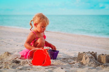 cute little girl play with sand on beach