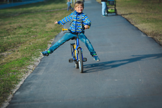 little boy doing tricks riding bike outdoors