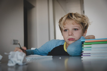 little boy tired stressed of reading, doing homework