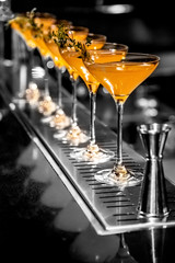 Cocktails in glasses on a bar counter.