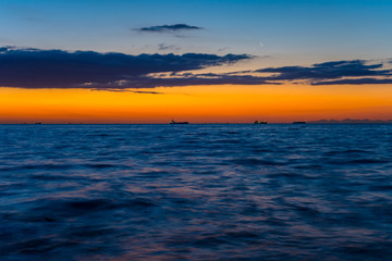 Obraz premium 夜明け前の海。空に月