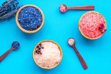 Aromas of bath salt. Coffee, rose, lavender near bowls with colorful bath salt on blue background top view