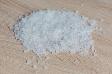 Fototapeta na wymiar close up of sea salt for cooking and aromatherapy on wooden background, selective focus