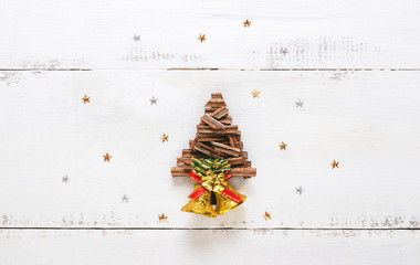 Top view of Christmas tree made from wood and star on white wooden background.