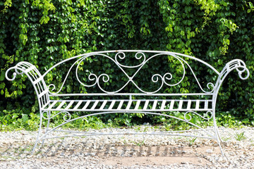 White iron chairs in the green garden.
