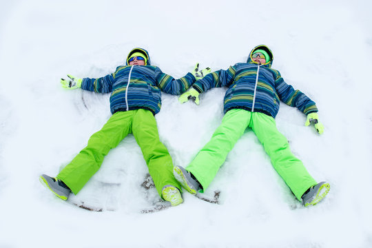 Happy boys in colorful winter clothes doing gymnastics on ice and snow. Glasses for skiing, snowboarding and sledging. A child is playing outdoors in the snow. Outdoor fun for winter holidays