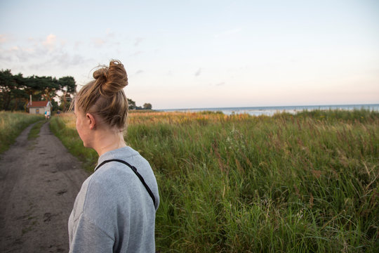 Young woman standing on an unpaved road in Ornahusen, Sweden