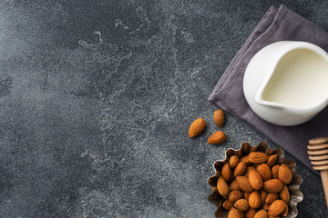 Almonds in a bowl and milk on the table. Selective focus. Copy space.