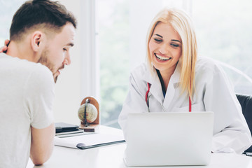 Woman doctor is talking to male patient in hospital office. Healthcare and medical service.