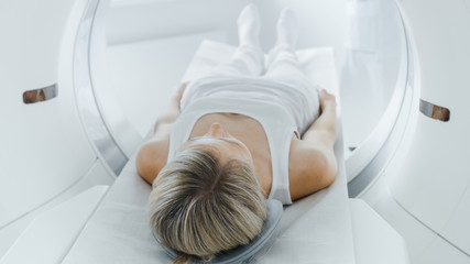 Female Patient Lying on a CT or MRI Scan, Bed is Moving inside Machine Scanning Her Body and Brain....