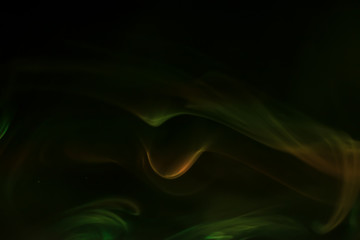 Yellow, green smoke (evaporation) on a black background