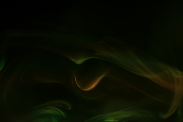Fototapeta premium Yellow, green smoke (evaporation) on a black background
