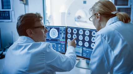 In Control Room Doctor and Radiologist Discuss Diagnosis while Watching Procedure and Monitors...