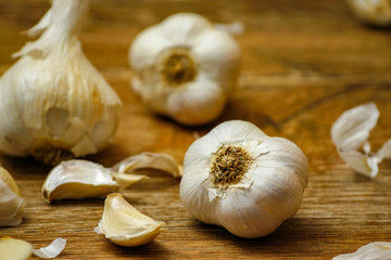 Garlic bulbs and garlic cloves on wooden rustic table. Close-up photo of healthy food.