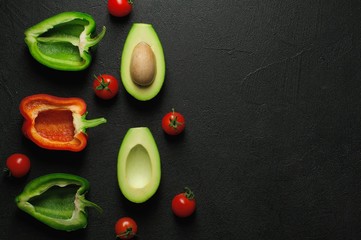 Healthy food clean eating selection on gray background. Green and red bell pepper, avocado and tomatoes. Top view