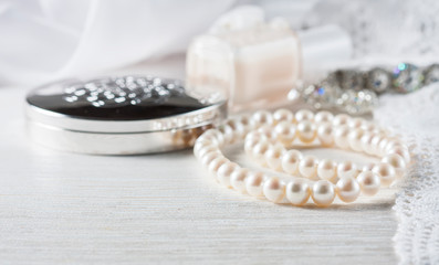 White pearl necklace on handmade lace background.