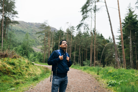 Man standing on a rural road in Glen Coe, Scotland