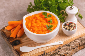 Bright tasty pureed carrot soup in clay bowl
