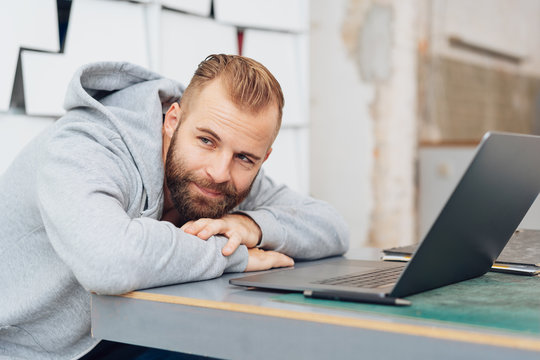 Man daydreaming while at work on laptop computer