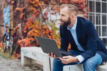 Entrepreneurial man working on laptop outdoors