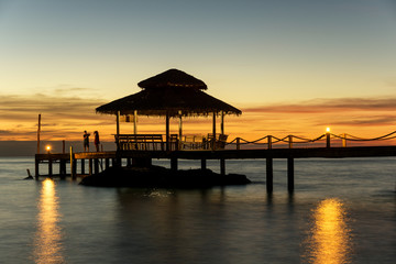 Fototapeta na wymiar Wooden pier between sunset in Phuket, Thailand. Summer, Travel, Vacation and Holiday concept.