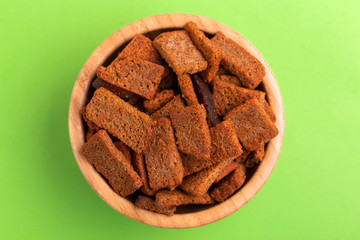 Rye salted crackers in wooden bowl on bright colored background